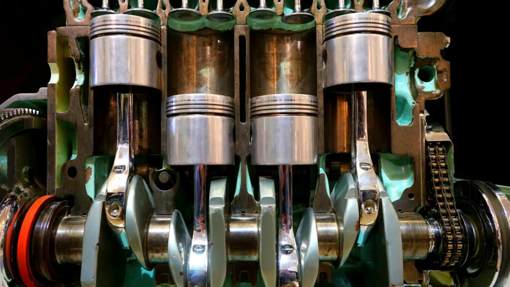 Close-up image of car engine pistons and crankshaft, showcasing mechanical components.